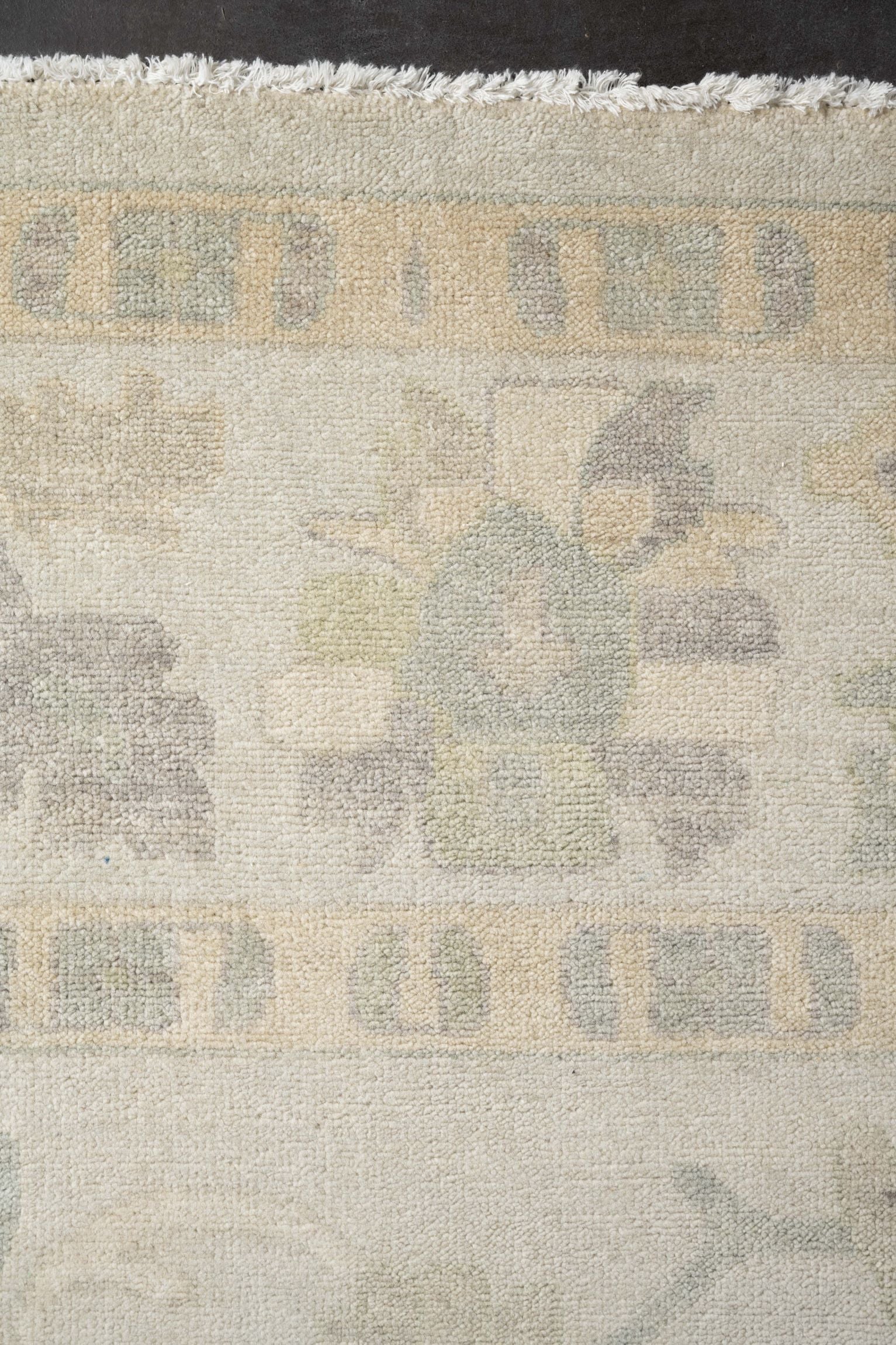 Neutral toned and hand-knotted Oushak style rug made of 100% New Zealand wool. This rug is comprised of tan, beige, taupe, gray, ivory, and blue colors.