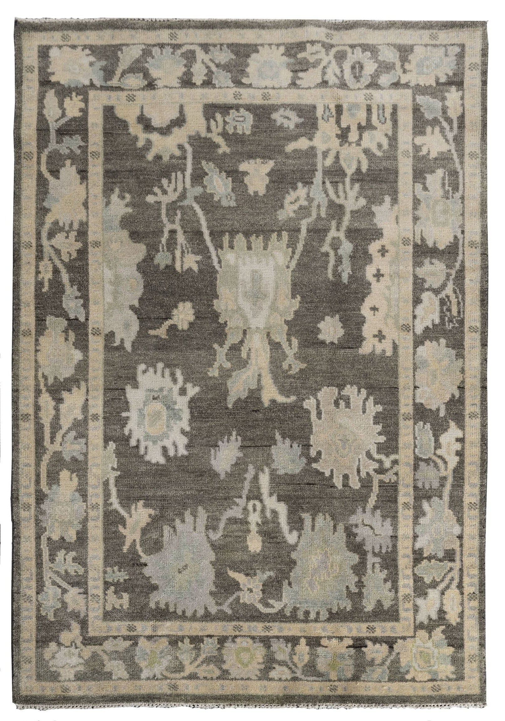 Neutral toned and hand-knotted Oushak style rug made of 100% New Zealand wool. This rug is comprised of beige, tan, charcoal, brown, and ivory colors. 