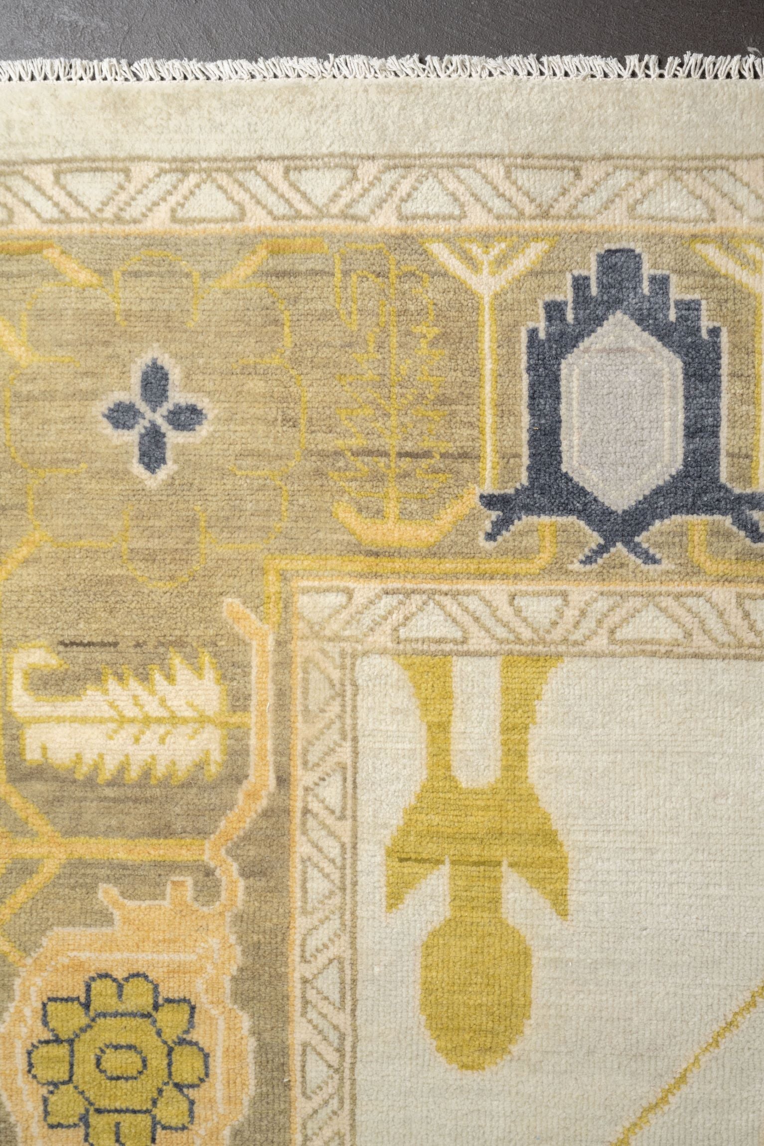 Neutral toned and hand-knotted Oushak style rug made of 100% New Zealand wool. This rug is comprised of tan, taupe, yellow, gold, blue, navy, gray, and ivory colors.