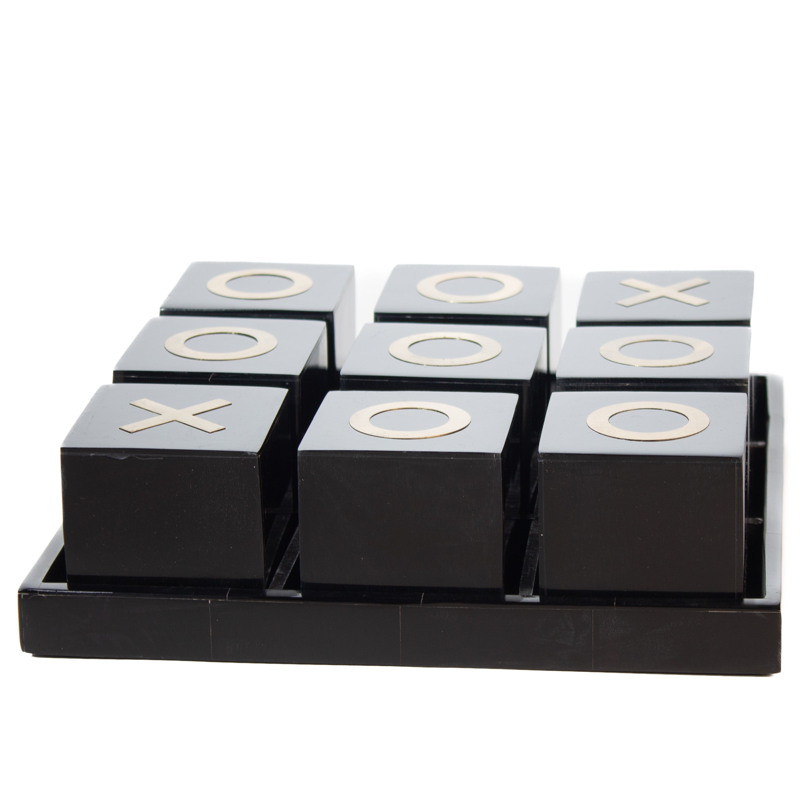 Decorative game. Black and Brass Tic Tac Toe.  Smooth black cubes with brass X's and O's contained in a black tray serving as the game board.
