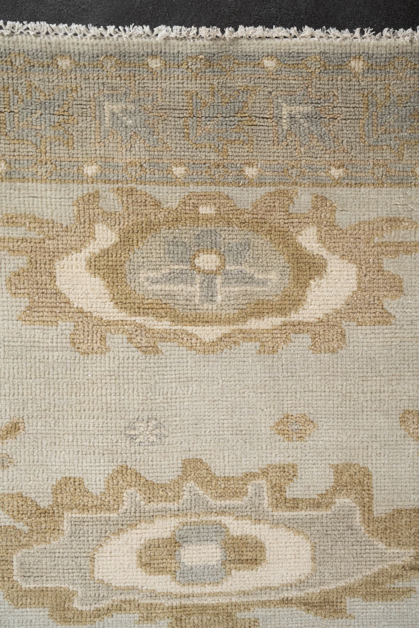 Neutral toned and hand-knotted Oushak style rug made of 100% New Zealand wool. This rug is comprised of tan, taupe, beige, brown, gray, and ivory colors.