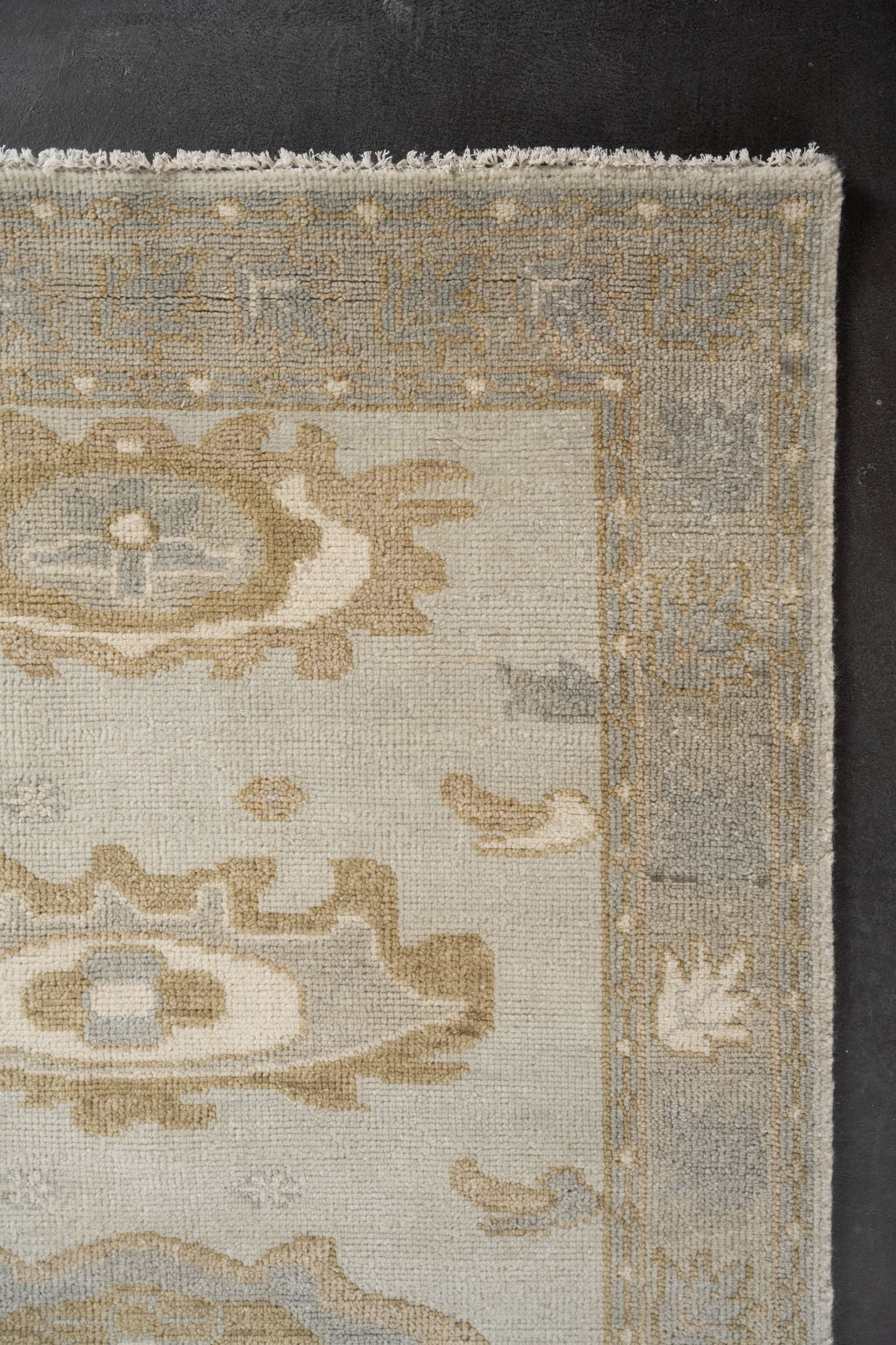 Neutral toned and hand-knotted Oushak style rug made of 100% New Zealand wool. This rug is comprised of tan, taupe, beige, brown, gray, and ivory colors.