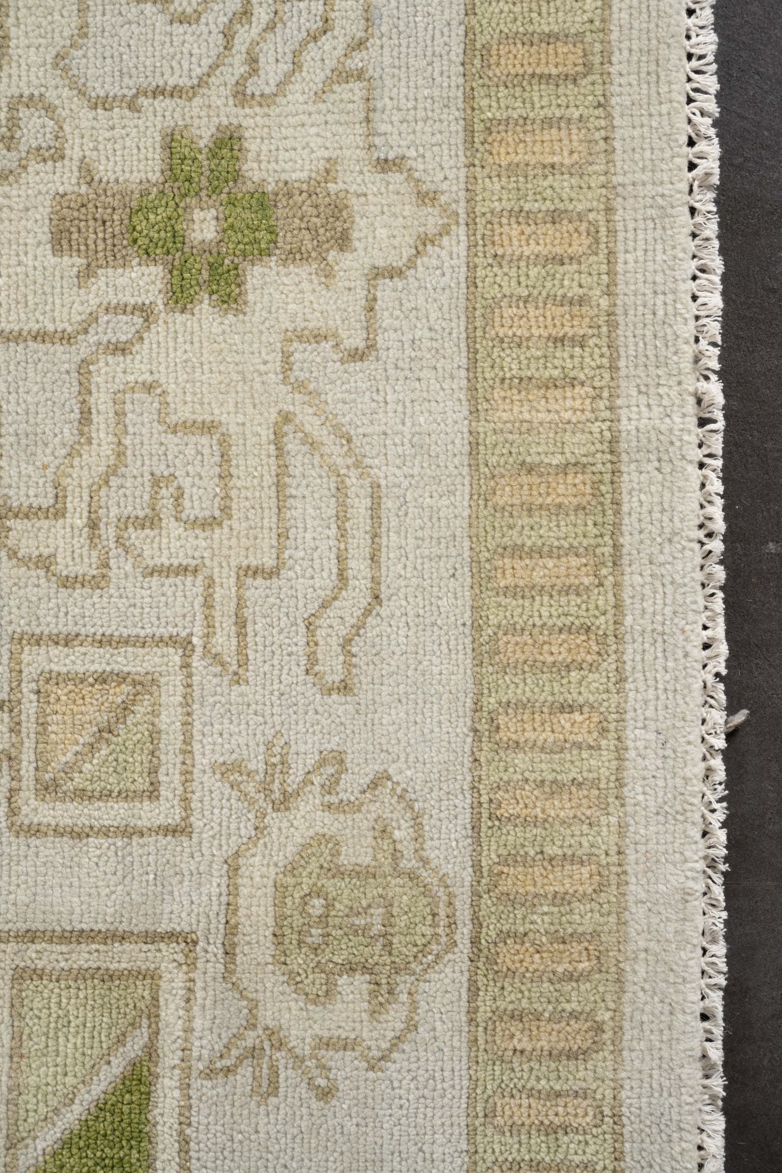 Neutral toned and hand-knotted Oushak style rug made of 100% New Zealand wool. This rug is comprised of green, beige, tan, ivory, brown, lime green, and gray colors.