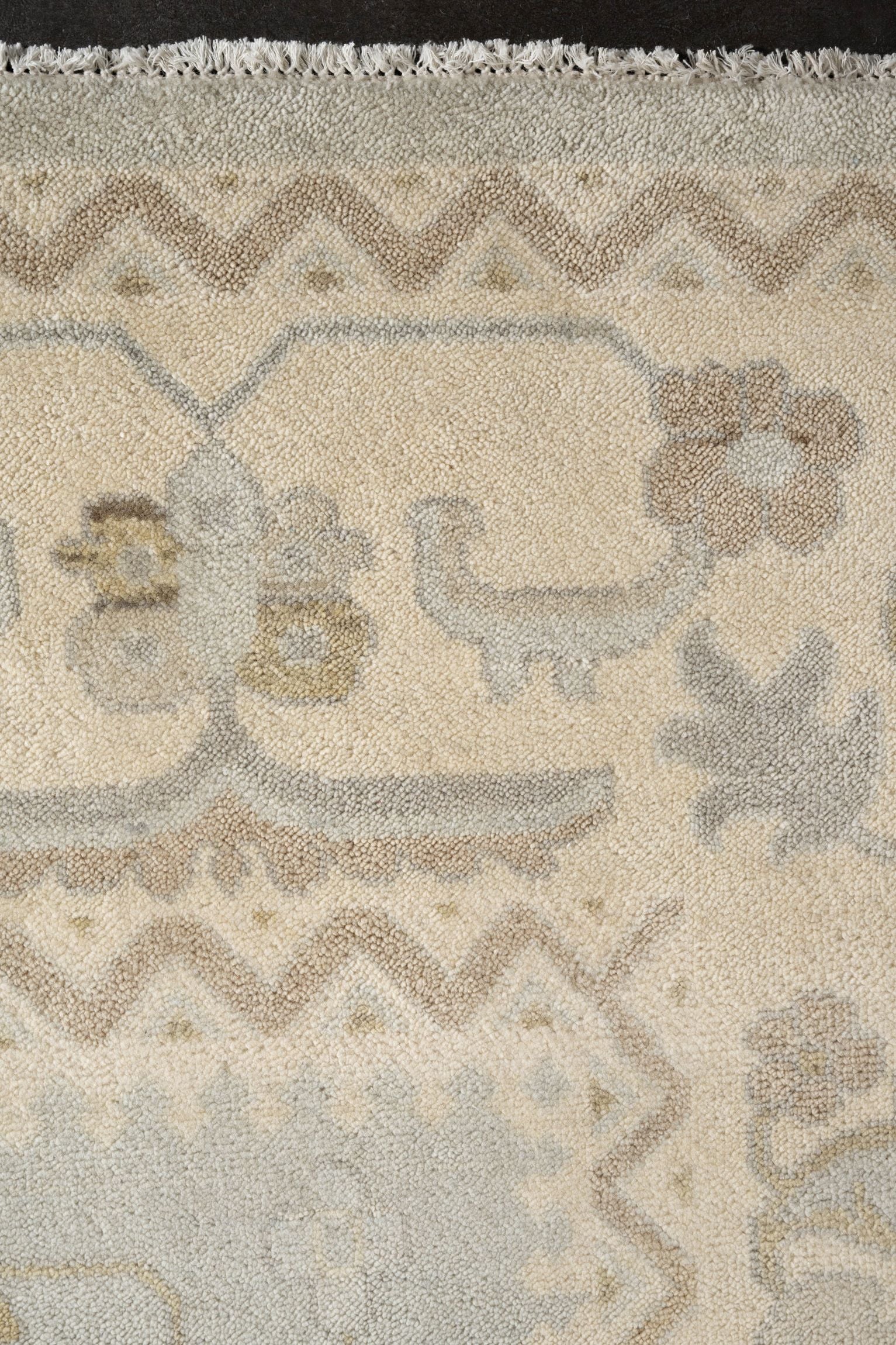 Neutral toned and hand-knotted Oushak style rug made of 100% New Zealand wool. This rug is comprised of tan, beige, brown, gray, and blue colors.