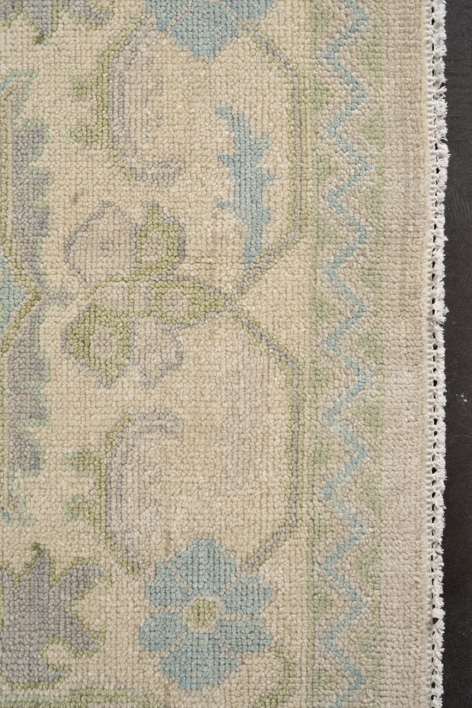 Neutral toned and hand-knotted Oushak style rug made of 100% New Zealand wool. This rug is comprised of blue, light blue, ivory, beige, gray, green, and light green colors.