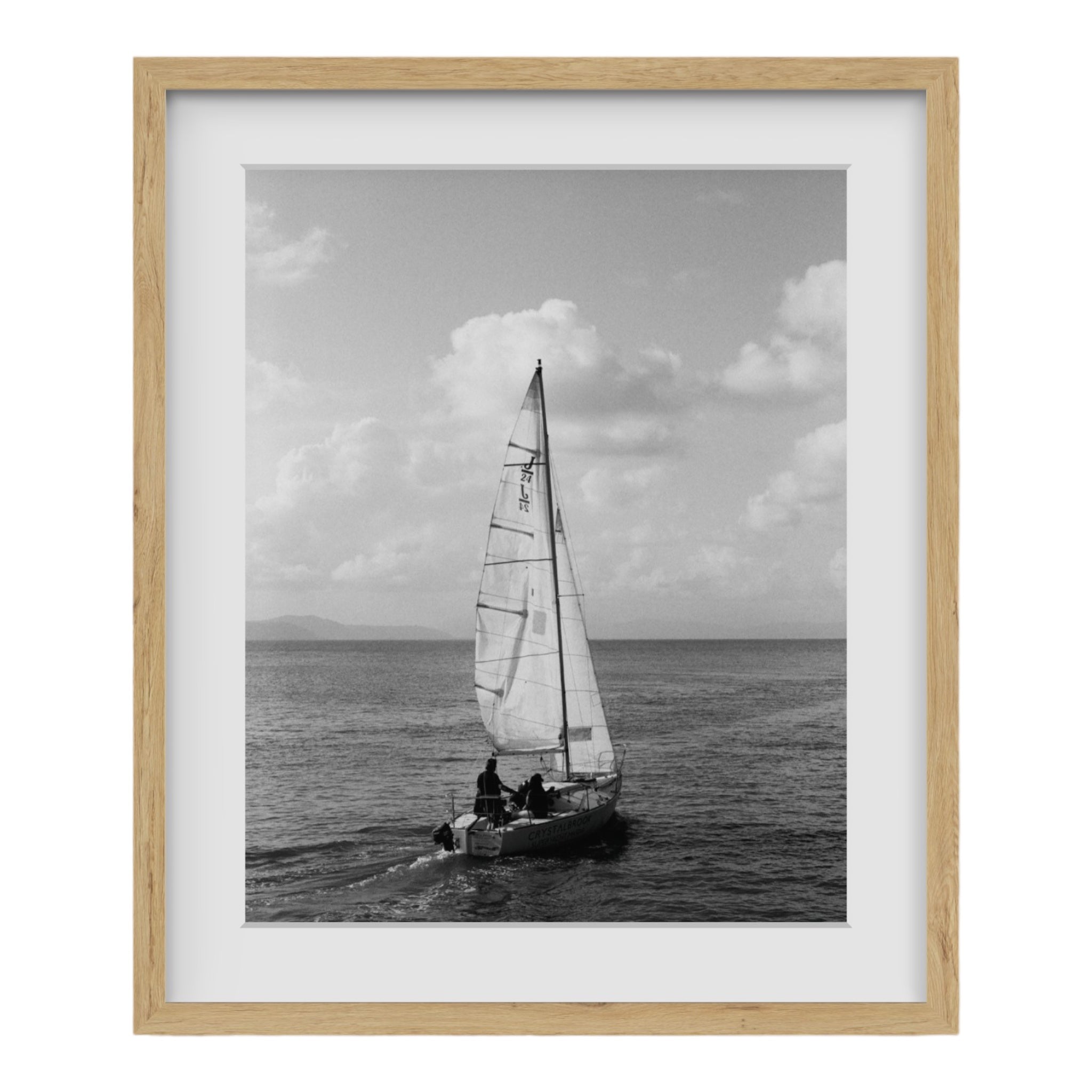 This professional photography for sale is a black and white photo by award-winning photographer Paul Scott taken in Cairns, Australia of a sailboat journeying along the Great Barrier Reef.